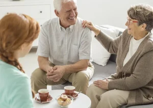 seniors enjoying friendly conversation over coffee with caregiver in cozy home