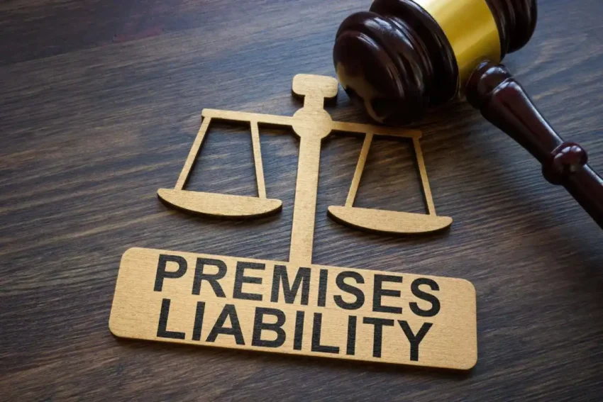 wooden gavel beside scales of justice showing premises liability text