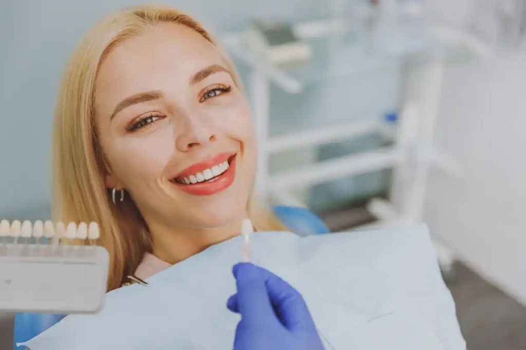 smiling dental patient selecting tooth shade during cosmetic consultation